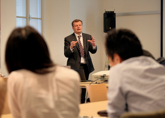 A business speaker sharing insights with a group of study-trip participants